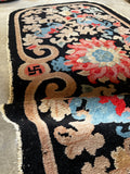 Worn antique Chinese wool rug with spiritual symbolism and curved rectangular shape

